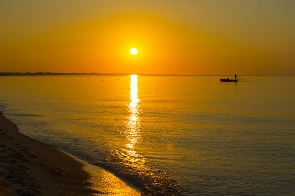 Восход солнца и лодка с рыбаками — стоковое фото