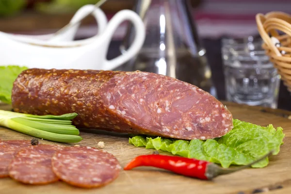 Sausage on wooden plate — Stock Photo, Image