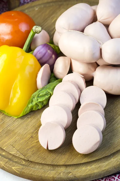 Sausages on wooden plate — Stock Photo, Image