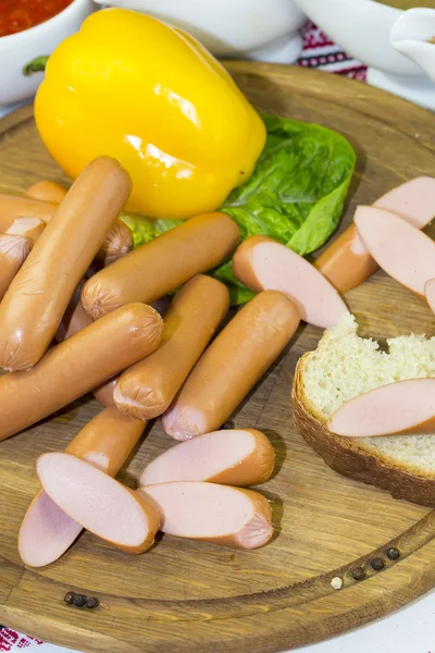 Sausages on wooden plate — Stock Photo, Image