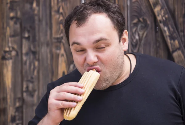 Mannen äter varmkorv — Stockfoto