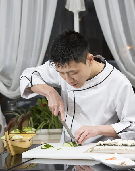 Chef slicing cucumber — Stock Photo, Image