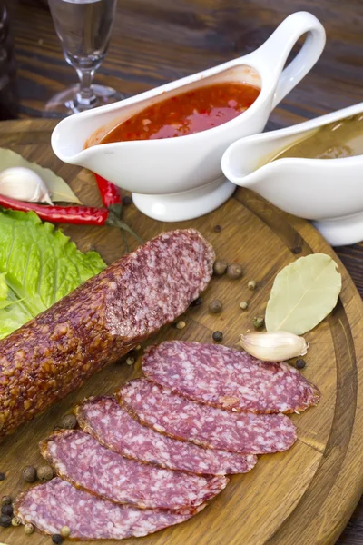 Sausage on wooden plate — Stock Photo, Image