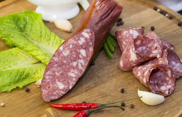 Sausage on wooden plate — Stock Photo, Image