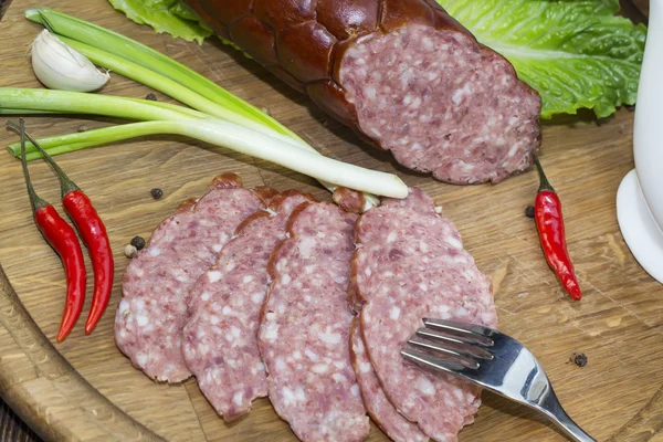 Sausage on a wooden plate — Stock Photo, Image