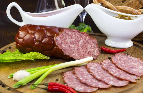 Sausage on a wooden plate — Stock Photo, Image