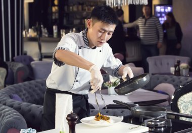 Şef mutfakta yemek hazırlıyor.