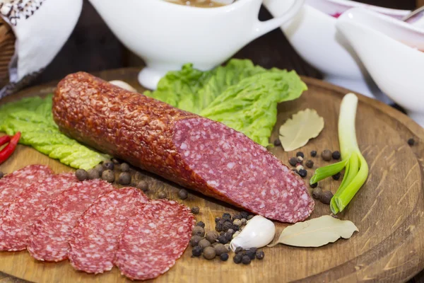 Sausage on wooden plate — Stock Photo, Image