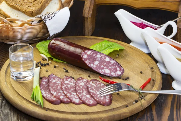 Sausage on wooden plate — Stock Photo, Image