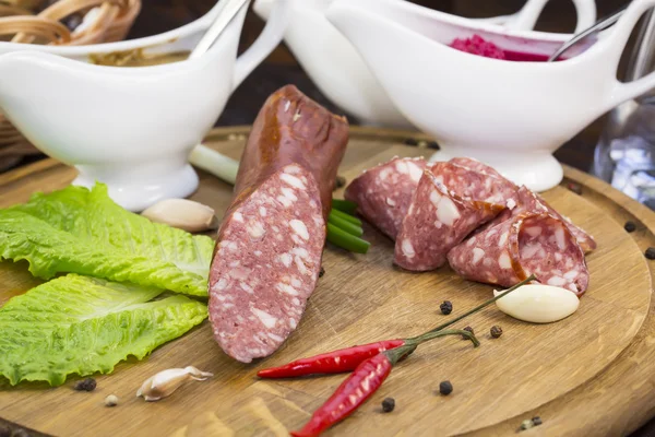 Sausage on a wooden plate — Stock Photo, Image