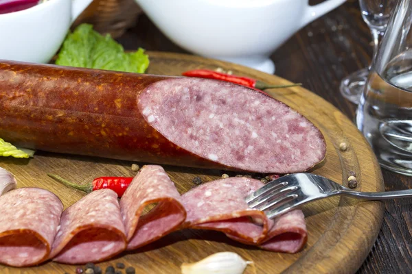 Saucisse sur une assiette en bois — Photo