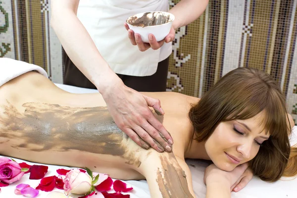 Tjejen gör en lera massage — Stockfoto