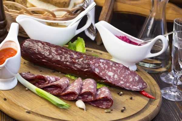 Sausage on wooden plate — Stock Photo, Image