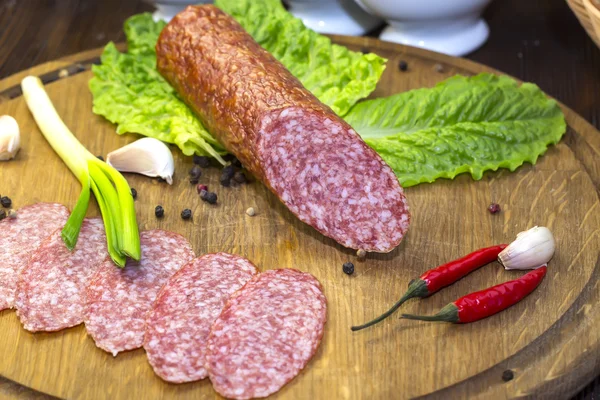 Sausage on wooden plate — Stock Photo, Image