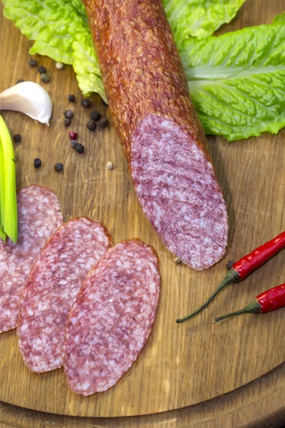 Sausage on wooden plate — Stock Photo, Image