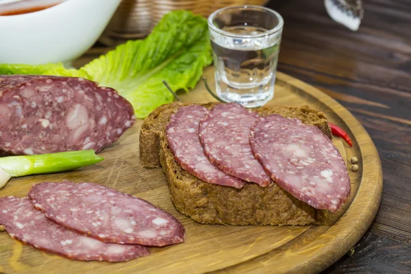 Sausage on wooden plate — Stock Photo, Image