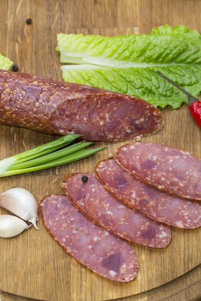Sausage on wooden plate — Stock Photo, Image
