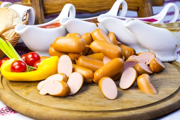 Sausages on wooden plate — Stock Photo, Image