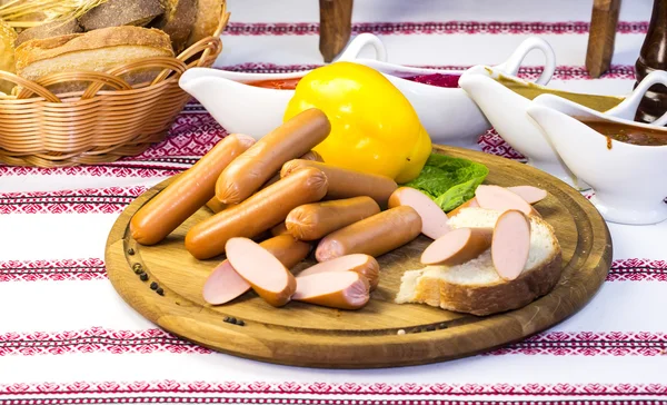 Sausages on wooden plate — Stock Photo, Image