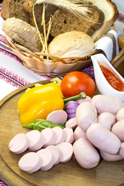 Sausages on wooden plate — Stock Photo, Image