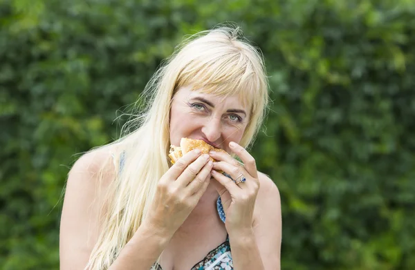 ハンバーガーを持つ大人の女性 — ストック写真