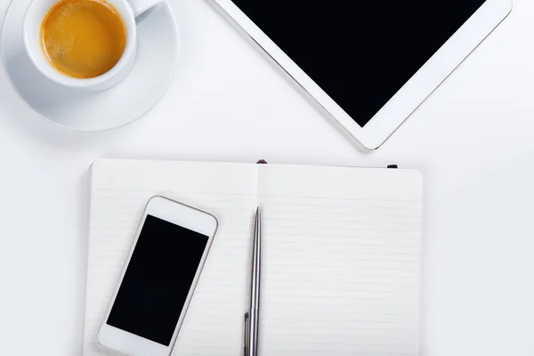 Tablette avec téléphone et tasse à café sur table blanche — Photo