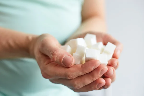 Мужские руки с кубиками белого сахара — стоковое фото