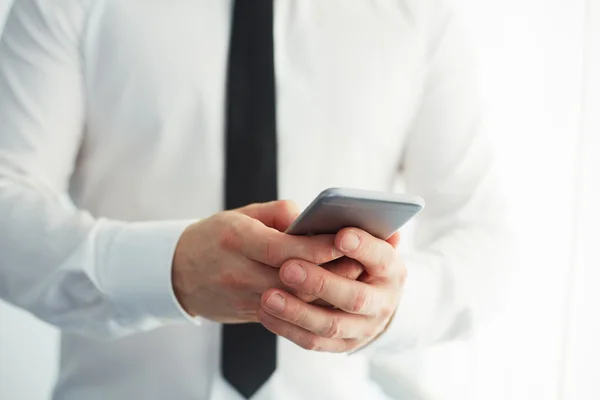 Uomo in possesso di uno smartphone e scrittura — Foto Stock