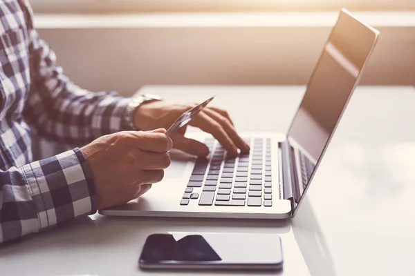 El hombre inserta datos para pagos en línea desde tarjetas de crédito —  Fotos de Stock