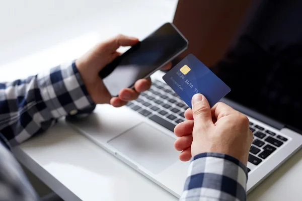 Man with credit card and mobile phone — Stock Photo, Image