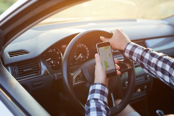 Homem sentado no carro segurando telefone celular com mapa gps navegação — Fotografia de Stock