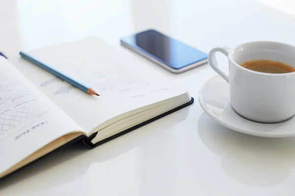 Lápis, diário aberto e xícara de café com sites de esboço — Fotografia de Stock