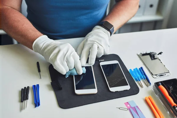 Técnico Servicio Sienta Detrás Una Mesa Limpia Pantalla Teléfono Móvil —  Fotos de Stock