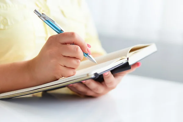 Young woman writes to black diary — Stock Photo, Image