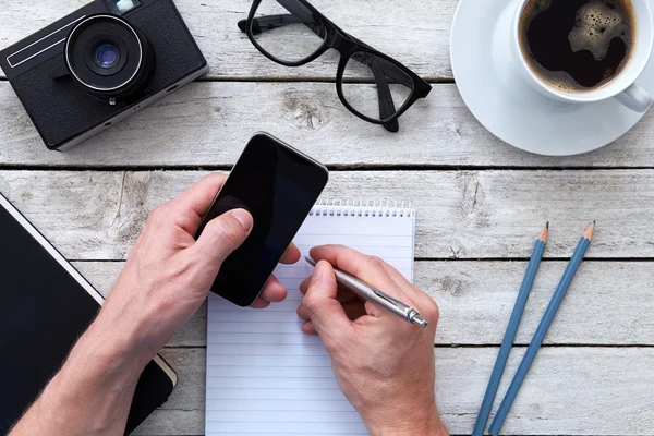 Bovenaanzicht van een hand met mobiele telefoon — Stockfoto