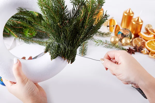 Mujer colocando ramas en la corona de Navidad — Foto de Stock