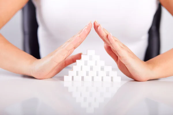 Female hands over a pyramid of sugar
