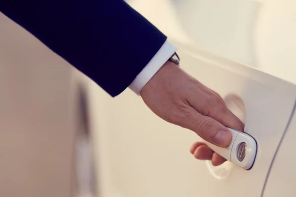 Hand of businessman opening a car door — Stock Photo, Image