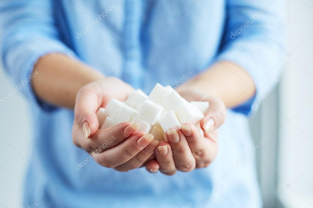 Woman holding white sugar cubes