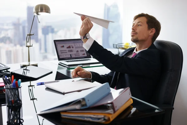 Gelangweilte Angestellte werfen Papierflugzeug ins Büro — Stockfoto