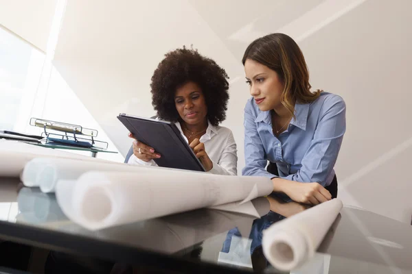 Vrouwen Architect ontwerpers met Tablet Pc en blauwdrukken — Stockfoto