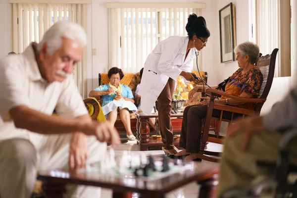 Hospice-arts meten van de bloeddruk met Senior vrouw — Stockfoto