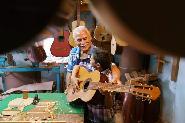 Chico aprende a tocar la guitarra con el abuelo del hombre mayor — Foto de Stock