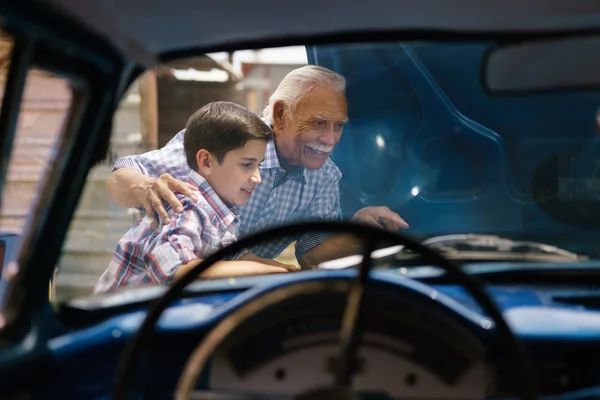 Pojke med morfar ser bilen motorn av äldre Man — Stockfoto