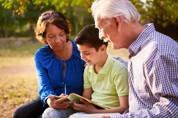 Nonni aiutare il bambino a fare i compiti a casa — Foto Stock