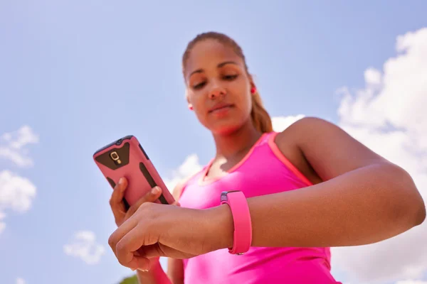 Mujer sincronizando reloj de fitness Fitwatch con teléfono —  Fotos de Stock