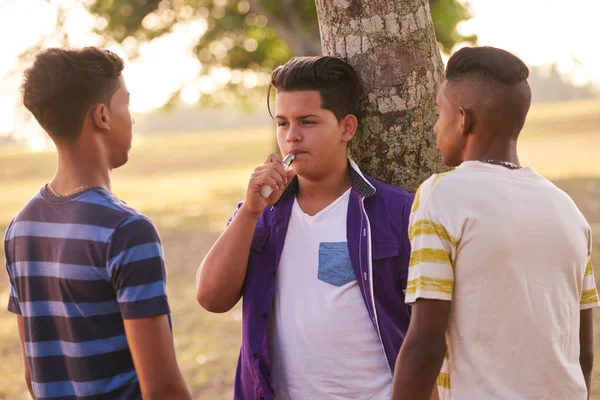 Grupo de adolescentes no parque menino fumar cigarro eletrônico — Fotografia de Stock