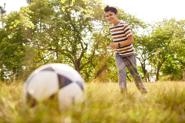 Giovane ragazzo che gioca a calcio gioco colpire palla — Foto Stock