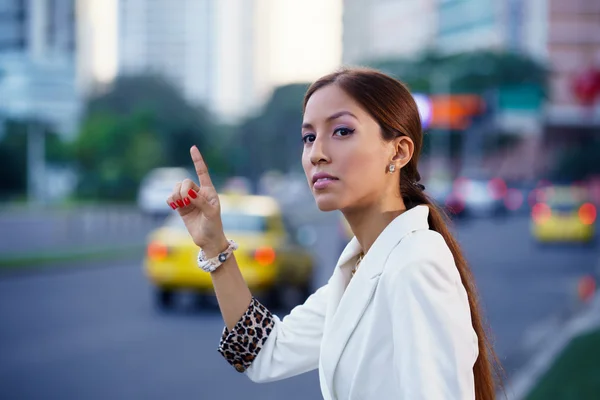 Latina businesswoman calling taxi car leaving work — Stock Photo, Image