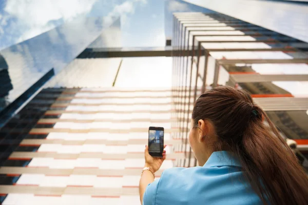 Людина знімає фото офісної будівлі з телефоном — стокове фото
